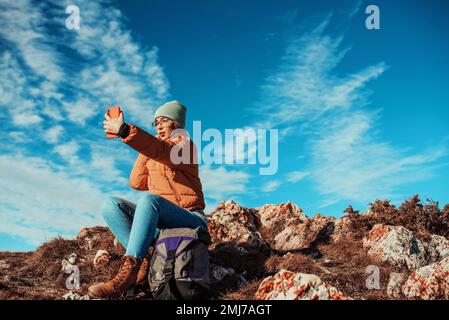 Eine Frau macht ein Selfie mit einem Smartphone auf einem Berg Stockfoto