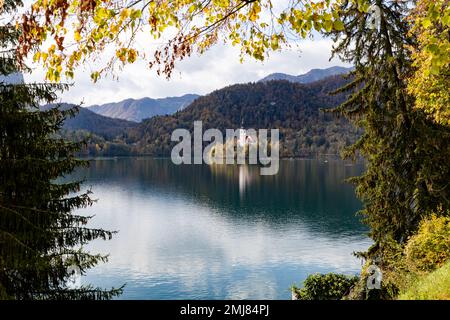 Der berühmte alpine Bled-See (Blejsko jezero) in Slowenien, herrliche Herbstlandschaft. Malerischer Blick auf den See, Insel mit Kirche, Berge und bewölktem Himmel, Stockfoto