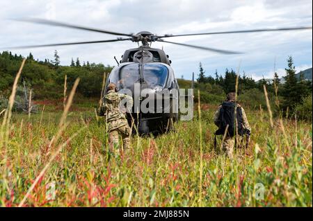 U.S. Air Force Tech. Sergeant Anthony Downs und Stabsleiter Derek Bolton, Stabsoffiziere, die der 3. Combat Weather Squadron zugeteilt sind, kehren während einer Vermessung der Geronimo Drop Zone in einen Alaska National Guard UH-72A Lakota Light Utility Helicopter zurück, bevor die nächsten Luftlandeoperationen auf der Joint Base Elmendorf-Richardson, Alaska, am 25. August 2022, stattfinden. Das 1. CWS bietet Bodenstreitkräfte und Luftfahrtanlagen vorausschauende atmosphärische Beobachtungs- und maßgeschneiderte Ausbeutungsfähigkeiten. Combat Weather, JBER, Stab Wetteroffizier, Stockfoto
