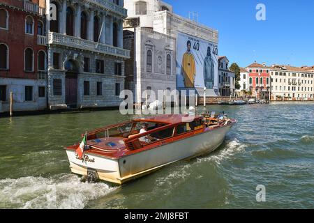 Taxiboot auf dem Canal Grande und der Kirche San Geremia mit restaurierter Fassade und einem Werbebanner, Venedig, Venetien, Italien Stockfoto