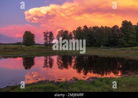 Ein schöner Sonnenuntergang über einem Bauernfeld im Norden von Wisconsin. Stockfoto