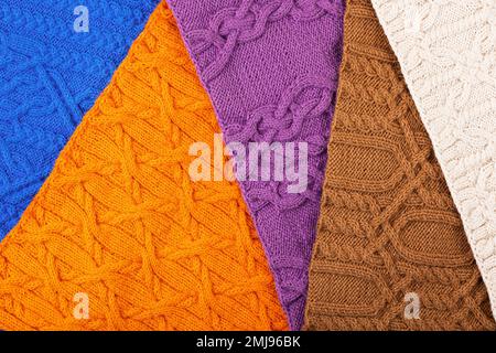 Gestrickter Hintergrund: Blau, lila, braun, orange und beige. Großer Strickstoff mit Muster. Nahaufnahme einer Strickdecke. Stockfoto