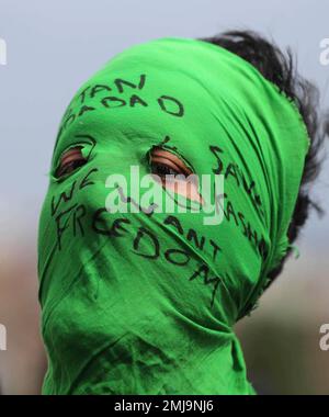A masked Kashmiri protester shouts freedom slogans as other holds ...