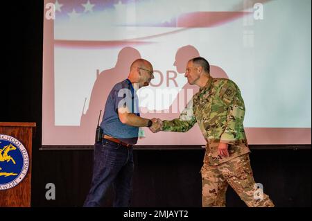 Von rechts überreicht Oberst Matt Husemann, 436. Luftwaffenkommandant, Jason Payne, Direktor der Welch-Grundschule, eine Münze während einer HELDENVERSAMMLUNG auf dem Luftwaffenstützpunkt Dover, Delaware, 26. August 2022. Die Versammlung führte das neue HELDENBELOHNUNGSSYSTEM der Schule ein, das die Schüler ermutigt, sich ehrenhaft, engagiert und verantwortungsbewusst zu verhalten und andere einzubeziehen. Stockfoto