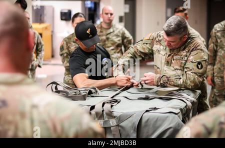 Staff Sgt. Jason King, Woodbine, Iowa, einheimischer Sergeant und Platoon Sergeant, Kompanie D, 1. Bataillon, 168. Infanterie-Regiment, Iowa Army National Guard, assistiert einem Ausbilder bei einer Vorführung der Traglast während eines Pathfinder-Kurses im Camp Dodge in Johnston, Iowa, am 26. August 2022. Der Kader, der dem Army National Guard Warrior Training Center in Fort Benning, Georgia, zugewiesen wurde, deckt während des Kurses flugmedizinische Evakuierungen, Nahkampfangriffe, Boden-zu-Luft-Kommunikationsverfahren und vieles mehr ab. Stockfoto