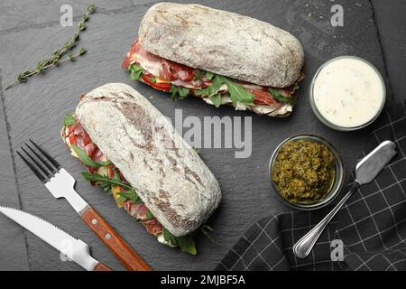 Flach liegend mit leckeren Sandwiches auf grauem Tisch Stockfoto