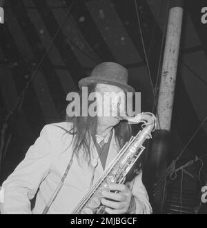 Niederländische Geschichte: Künstler treten im Circus Boltini auf. Laut der Originalunterschrift für dieses Foto ist dieser Mann der berühmte holländische Oboist Jaap Statijn, der im Alter von 70 Jahren ein Saxophon spielt und als musikalischer Clown verkleidet ist; Datum: 4. Juli 1962 Stockfoto