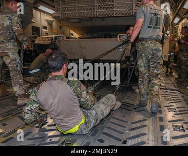 Flugzeuge des 386. Expeditionary Logistics Readiness Squadron neben den 816. Expeditionary Airlift Squadron Loadmasters sichern sich einen M-1/A2 Abrams Hauptkampfpanzer an Bord eines C-17 Globemaster III-Flugzeugs am 12. August 2022 auf dem Ali Al Salem Air Base, Kuwait. Für den Tank M-1 Abrams sind 38 Ketten erforderlich, die während des Fluges sicher befestigt werden müssen. Stockfoto