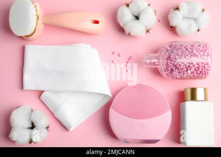 Flache Laienzusammensetzung mit Gesichtsreinigungsbürsten auf pinkfarbenem Hintergrund. Kosmetische Werkzeuge Stockfoto