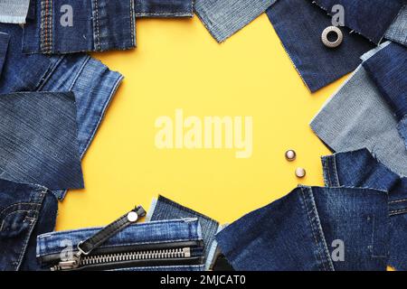 Rahmen aus ausgeschnittenen Jeans auf gelbem Hintergrund. Platz für Text Stockfoto