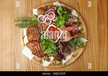 Köstliches geröstetes Fleisch, serviert auf einem Holztisch, Blick von oben Stockfoto