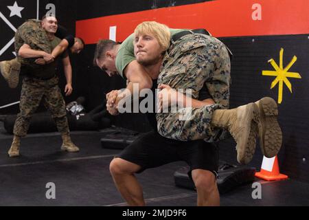Paddy Pimblett, ein gemischter Kampfkünstler, Feuerwehrmann trägt die USA Marine Corps Sgt. Ryan Slubowski, ein Funker der Force Reconnaissance Company, 1. Aufklärungsbataillon, 1. Marine Division, während eines Martial Arts Program Workout des Marine Corps im Dojo 9. Communications Battalion im Marine Corps Base Camp Pendleton, Kalifornien, 26. August 2022. Pimblett tritt in der Abteilung Lightweight der Ultimate Fighting Championship an und besuchte Camp Pendleton, um mit den Marines zu trainieren und seine Erfahrungen zu teilen. Pimblett wurde kürzlich ein Fürsprecher für psychische Gesundheit und Selbstmordbewusstsein, Enco Stockfoto