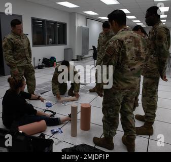 USA Air Force Airmen, die dem 319. Reconnaissance Wing und Tawni Havala, der University of North Dakota Simulationsausbildung und mobilen Koordinator zugewiesen wurden, überprüfen Techniken, wie eine blutende Wunde während einer medizinischen Trainingsübung am 26. August 2022 auf dem Luftwaffenstützpunkt Grand Forks, North Dakota. Die Schulung bot Airmen die Möglichkeit, durch simulierte medizinische Notfallszenarien zu arbeiten. Stockfoto