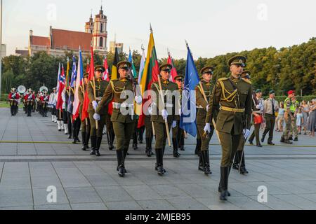 Eine Ehrengarde der litauischen Streitkräfte mit den Flaggen der NATO-Alliierten marschiert während einer Parade, die zu einer militärischen Tätowierung in Vilnius, Litauen, führte, am 27. August 2022. Litauen lud alliierte Nationen zum ersten Mal in seiner Geschichte zu einer Militärtätowierung ein, darunter die 1. Infanterie-Division-Band, die stolz neben den NATO-Verbündeten während einer historischen, von den litauischen Streitkräften ausgerichteten Militärtätowierung auftritt. Stockfoto