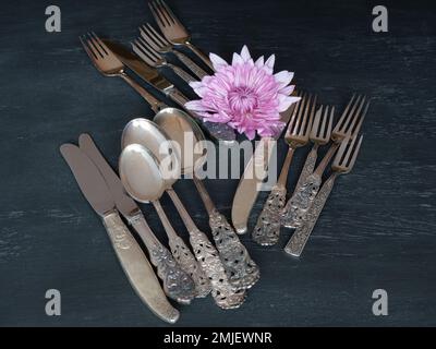 Eine Auswahl an silbernen Löffeln, Messern und Gabeln auf einem Tisch. Stockfoto