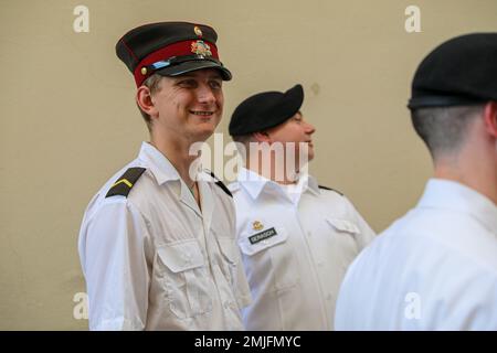 Ein Mitglied der lettischen Nationalgarde lächelt, während er sich mit 1. Soldaten der Infanterie-Division zusammensetzt, nachdem er am 28. August 2022 in Vilnius, Litauen, eine Militärtätowierung durchgeführt hat. Die Big Red One Band ist unter anderem der 1. Infanterie-Division zugeteilt und tritt stolz zusammen mit NATO-Verbündeten während eines historischen, von den litauischen Streitkräften ausgerichteten Militärtätowierens auf. Stockfoto