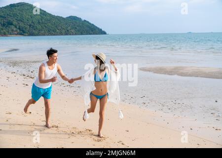 Glückliches junges Paar, dass am Strand Stockfoto