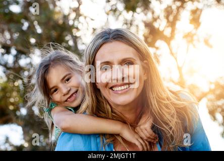 Meine Tochter ist mein ein und alles. Porträt einer glücklichen Mutter und Tochter, die eine Huckepackfahrt im Freien genießen. Stockfoto