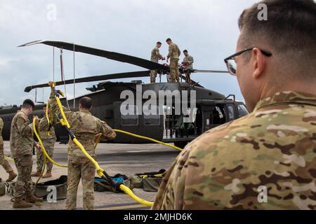 Soldaten, die dem 603. Luftfahrt-Stützbataillon, der 3. Kampfluftfahrt-Brigade, der 3. Infanterie-Division, zugeteilt wurden, sicherten Seile zu einem UH-60 Blackhawk während einer Übung des Flugzeugabholungsteams am Hunter Army Airfield, Georgia, am 30. August 2022. DART-Übungen bereiten Soldaten darauf vor, ein Flugzeug in jedem Zustand sicher und effizient zu Bergen. Stockfoto