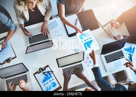 Für dieses Projekt sind alle Mann an Deck erforderlich. Foto eines Teams von Geschäftsleuten, die an einem Tisch im Büro arbeiten. Stockfoto