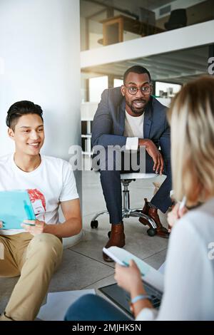 Ihre kreativen Ideen kombinieren. Eine Gruppe von Kollegen, die in einem modernen Büro ein Brainstorming durchführen. Stockfoto