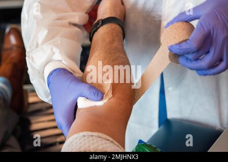 LUFTWAFFENSTÜTZPUNKT RAMSTEIN, Deutschland – Kayle Abad, Phlebotomist des Armed Services Blood Program, legt einen Verband über den Arm eines Spenders am Luftwaffenstützpunkt Ramstein, Deutschland, 30. August 2022. Das Armed Services Blood Program veranstaltet monatliche Blutspenden auf dem Luftwaffenstützpunkt Ramstein. Stockfoto