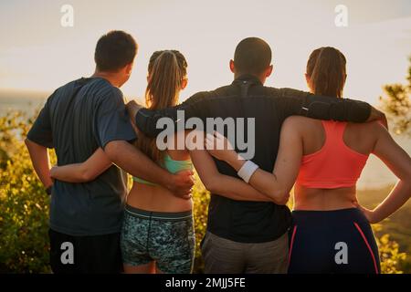 Es sind die kleinen Dinge, die es wert machen. Rückansicht einer Fitnessgruppe, die eine malerische Aussicht bewundert. Stockfoto