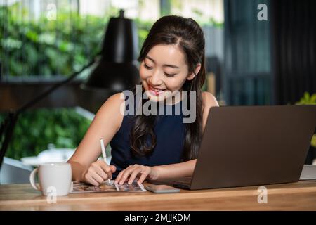 Eine junge Frau benutzt den Computer Stockfoto