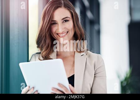 Es ist die einzige Möglichkeit, Geschäfte zu machen. Porträt einer erfolgreichen Geschäftsfrau, die ihr Tablet im Büro benutzt. Stockfoto