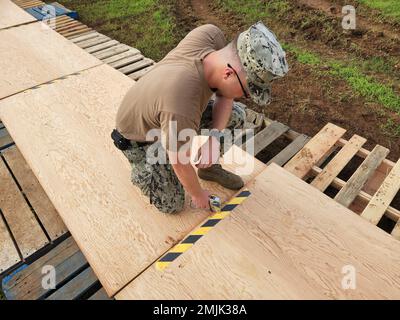 SANTA RITA, Guam (30. August 2022) Gerätebetrieb 3. Klasse Nicholas Fletcher, dem mobilen Marinebataillon (NMCB) 11 zugeteilt, unterstützt die Wartungseinheit 303 des Baubataillons, indem er einen sauberen und sicheren Gang für das Expeditionary Maritime Operations Center von Pacific Vanguard (1. September 2022) schafft. Die NMCB 11 wird vorwärtsversetzt, um Bauarbeiten, humanitäre Hilfe und die Zusammenarbeit im Bereich der Theatersicherheit in den USA durchzuführen Sechster und siebter Flottenbereich. Stockfoto