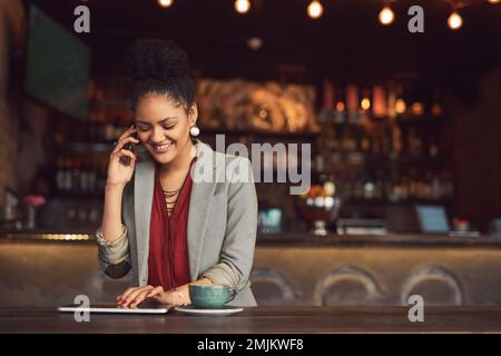 Business und Mittagessen in einem. Eine junge Geschäftsfrau, die in einem Café mit einem Handy spricht. Stockfoto