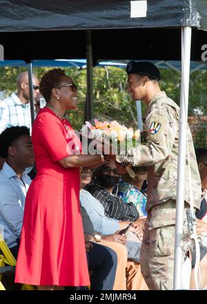 Sgt. Jose Ducassa, die 2022 in Fort Jackson nicht kommissionierte Offizierin des Jahres, präsentiert Stephanie Kelly während ihrer Ehemänner Brig einen Strauß gelber Rosen. General Jason E. Kelly, Zeremonie zur Befehlsänderung am 31. August am Victory Field. Brigg. General Kelly übernahm während der Zeremonie die Verantwortung für die Position als 53. Kommandierender General von Fort Jackson. Stockfoto