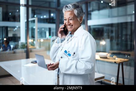 Arzt, Seniorin und Telefongespräch im Spitalgespräch, Sprechen und Networking. Smartphone, Nacht und Ärztin in der Diskussion Stockfoto