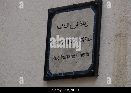 Ein kleines Straßenschild dreisprachiges arabisches französisch und Berber in der mittelalterlichen Medina von Fez Fes (Altstadt). Marokko. Stockfoto