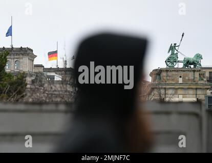 Berlin, Deutschland. 27. Januar 2023. Eine Frau geht durch das Denkmal für die ermordeten Juden Europas in Berlin, Deutschland, am 27. Januar 2023. Die Gedenkstätte im Zentrum Berlins wurde erbaut, um etwa 6 Millionen Juden zu gedenken, die von den Nazis im Zweiten Weltkrieg getötet wurden Im Jahr 2005 verabschiedete die Generalversammlung der Vereinten Nationen eine Resolution, mit der der 27. Januar zum Internationalen Gedenktag zum Gedenken an die Opfer des Holocaust erklärt wurde. Kredit: Ren Pengfei/Xinhua/Alamy Live News Stockfoto