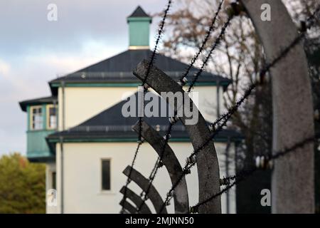 Oranienburg, Deutschland. 27. Januar 2023. Ein Zaun mit Stacheldraht befindet sich auf dem Gelände des Sachsenhausen Memorial and Museum. Während einer gemeinsamen Veranstaltung des Brandenburger Landesparlaments und der Gedenkstätte wurde zum ersten Mal, anstatt einen Kranz zu legen, eine Tonband-Kunstaktion mit der Frage durchgeführt: "Warum erinnern Sie sich heute? Kredit: Soeren Stache/dpa/Alamy Live News Stockfoto