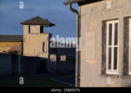 Oranienburg, Deutschland. 27. Januar 2023. Die Kaserne „Pathologie“ und ein ehemaliger Wachturm stehen auf dem Gelände des Sachsenhausen-Gedenkmals und -Museums. Während einer gemeinsamen Veranstaltung des Brandenburger Landesparlaments und der Gedenkstätte wurde zum ersten Mal, anstatt einen Kranz zu legen, eine Tonband-Kunstaktion mit der Frage durchgeführt: "Warum erinnern Sie sich heute? Kredit: Soeren Stache/dpa/Alamy Live News Stockfoto