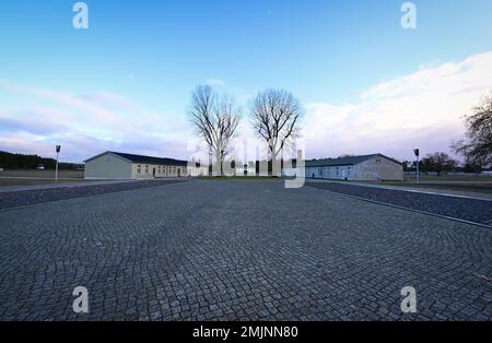 Oranienburg, Deutschland. 27. Januar 2023. Ein gepflasterter Pfad führt über das Gelände des Sachsenhausen-Gedenkmals und -Museums. Während einer gemeinsamen Veranstaltung des Brandenburger Landesparlaments und der Gedenkfeier wurde zum ersten Mal, anstatt einen Kranz zu legen, eine Tonband-Kunstaktion mit der Frage durchgeführt: "Warum erinnern Sie sich heute?" Kredit: Soeren Stache/dpa/Alamy Live News Stockfoto