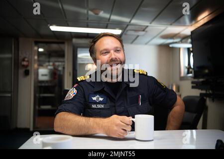 Royal Norwegian Navy Lt. Cmdr. Havard Nilsen lacht bei einem Treffen vor der Inspektion an Bord des Schiffes der kanadischen Küstenwache Cape Roger, 31. August 2022. Nilsen wird vorübergehend zusammen mit dem USCGC-Bär (WMEC 901) eingesetzt, um die Besatzung bei der Durchfahrt durch unbekannte Gewässer im Nordatlantik zu unterstützen. Stockfoto