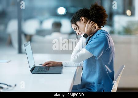 Arzt, Laptop und Nackenschmerzen in der Nacht überlastet, gestresst oder Burnout am Schreibtisch im Krankenhaus. Frau Medizinerin leidet unter Schmerzen Stockfoto