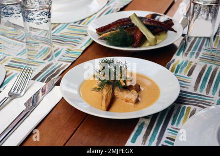 Traditionelle griechische Küche, Lankerdafisch mit Tintenfisch, mediterranes traditionelles Menü, gegrillte Seebrassen, Stockfoto