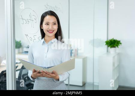 Junge Geschäftsfrau mit einer Mappe Stockfoto