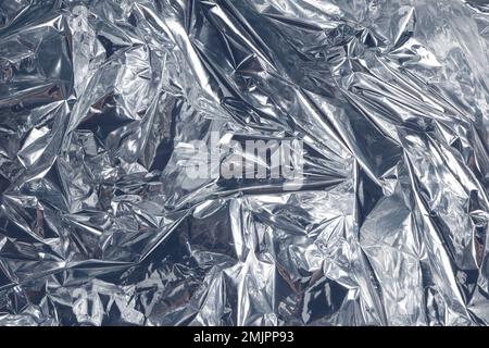 Metallischer zerknitterter Hintergrund. Minimale abstrakte Zusammensetzung. Strukturierter Hintergrund für Karte oder Einladung. Platz für Ihren Text Stockfoto