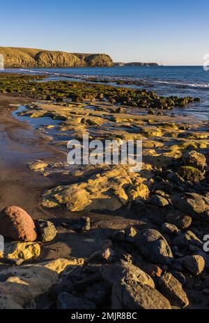 Playa de las Coloradas Strand mit Blick auf die sonnenbeleuchteten Klippen von Papagayo am späten Nachmittag Stockfoto