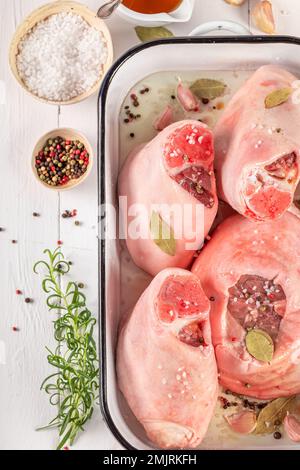 Zutaten für geröstetes Schweinefleisch, gebacken in einer ofenfesten Schale. Zutaten von rohem Schweinefleisch mit Gewürzen. Stockfoto