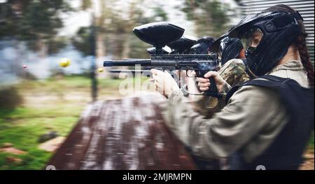 Paintball, Soldat und Action mit Pistole zum Schießen, Geschwindigkeit und militärisches Schlachtfeld mit Sport, Krieg und Fitness im Freien. Leute zusammen Stockfoto