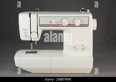Alte Nähmaschine auf grauem Hintergrund Stockfoto