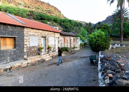 Einheimischer Mann, vorbei an alten traditionellen Häusern in der ältesten Siedlung auf Cabo verde, Cidade Velha Dorf auf der Insel Santiago in Cabo verde Stockfoto