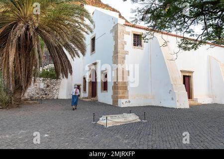 Einheimische Frau besucht die wunderschöne weiße Kirche Nossa Senhora do Rosário im ältesten Dorf auf Cabo verde, Cidade Velha auf der Insel Santiago Stockfoto