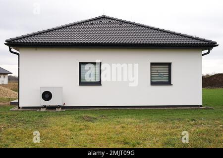 Wärmepumpeneinheit im Freien in einem modernen neuen Haus der Zukunft mit grüner elektrischer Energie und effizienter Wärmepumpe Stockfoto